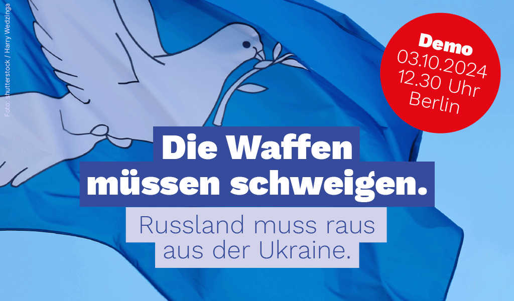 Hintergrund: Friedentaube auf einer Flagge. Demo 03.10.2024 - 12.30 Uhr - Berlin. Text: Die Waffen müssen schweigen. Russland muss raus aus der Ukraine.